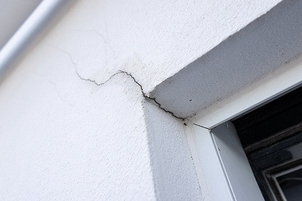Fissures sur les murs d'une maison à cause d'un défaut de construction.