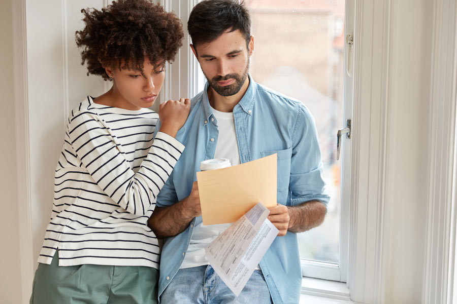 Un couple de locataires lisant leur contrat de bail pour éviter tout litige locataire propriétaire